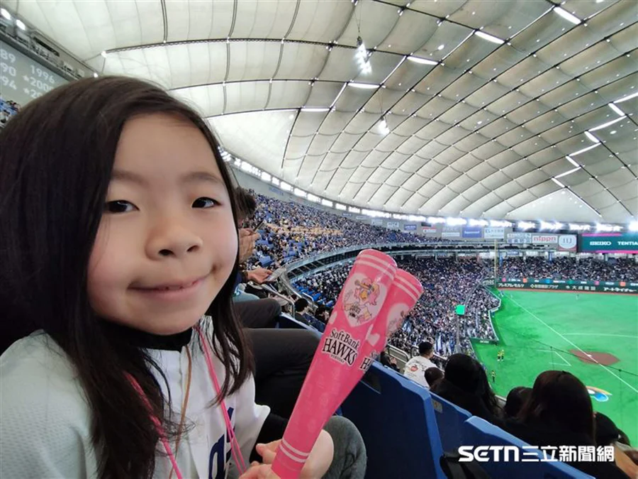 Young baseball fan sitting in the stands watching the World Baseball Classic game